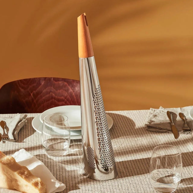 Alessi Todo Käsereibe als Parmesanreibe auf dem gedeckten Tisch neben Parmesan und Brot