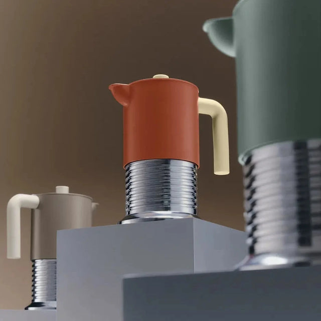 Alessi Vite Espressokocher in allen drei Farben – Braun, Grau und Grün – auf geometrischen Sockeln, Studioaufnahme