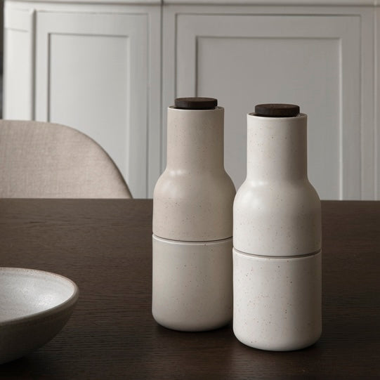 Audo Copenhagen Bottle Grinder Keramik Gewürzmühlen Set Sand auf dunklem Esstisch