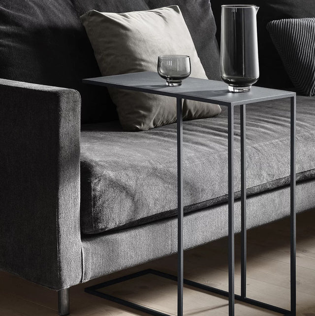 blomus Fera Beistelltisch Steel Gray unter das Sofa geschoben mit Glas und Karaffe