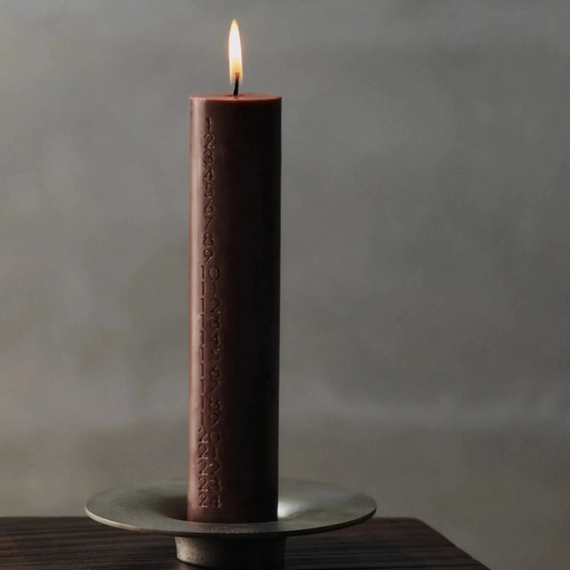 ferm LIVING Mura Adventskerze Dark Grape brennend im Kerzenhalter