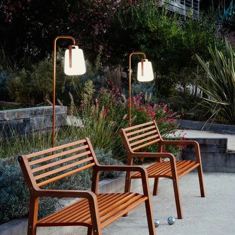 Fermob Balad² Akku-Lampe Kandierte Orange als Stehleuchte neben Parkbänken - Fermob