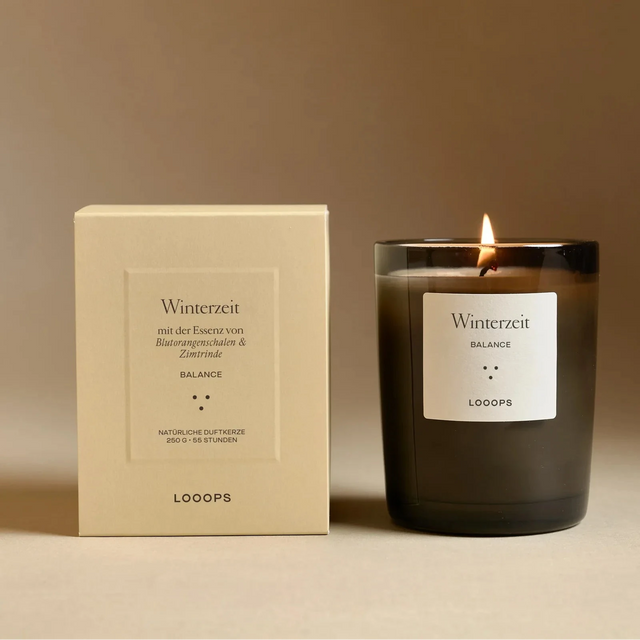 Looops Duftkerze Winterzeit 250 g – natürliche Duftkerze mit Zimt, Nelke und Orange neben der Geschenkverpackung