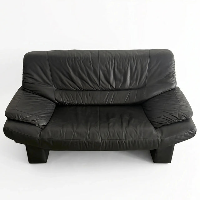 Postmodernes schwarzes Leder-Sofa im Vintage-Stil der 1980er Jahre in direkter Vorderansicht freigestellt auf Weiß