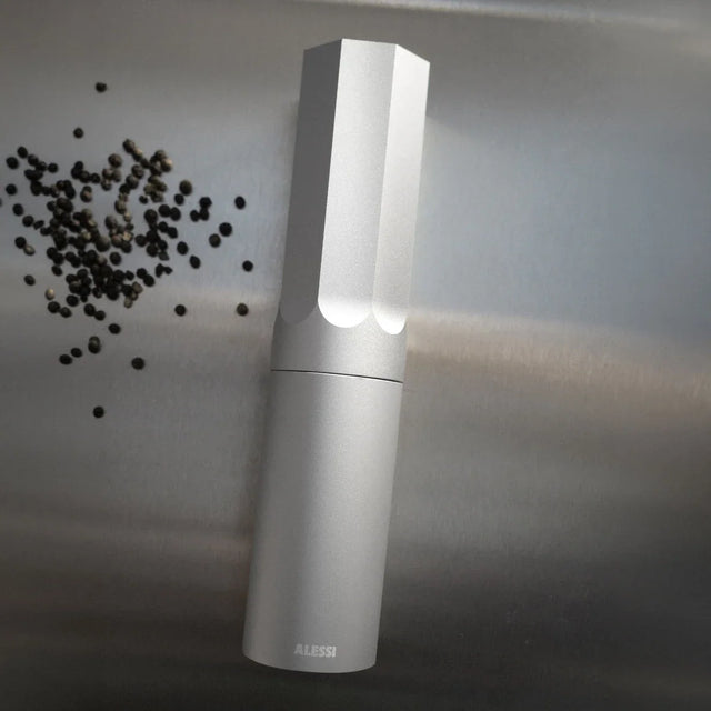 Alessi KG01 Gewürzmühle in Aluminium mit Pfefferkörnern auf Edelstahl