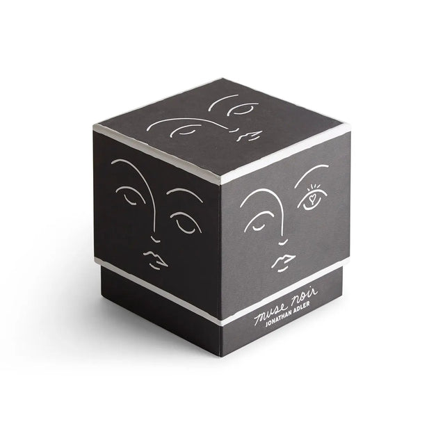 Muse Noir Duftkerze Jonathan Adler – schwarze Geschenkbox mit weißen Gesichts-Illustrationen