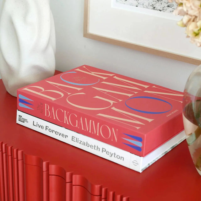 Art of Backgammon von Printworks – Verpackung als Deko-Objekt auf rotem Sideboard im Wohnzimmer