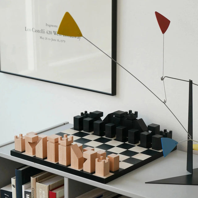 Schachspiel The Functionalist von Printworks auf Regal mit Kunstbüchern und Calder-Mobile, Lifestyle-Settin