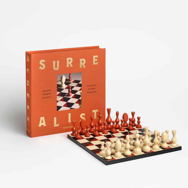 The Surrealist Schachspiel von Printworks – Verpackung neben aufgebautem Brett mit surrealen Figuren